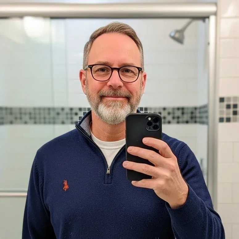 Image_fx+(1).png A man with glasses and a beard taking a selfie in a bathroom mirror.