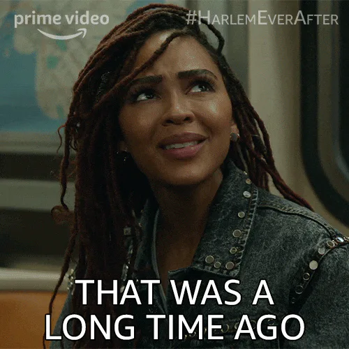 A woman with long locs looks up wistfully as on-screen text reads 'That was a long time ago.'