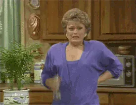 blanche-fanning.gif Blanche from The Golden Girls sprays water on her neck from a spray bottle in the kitchen, one hand on her hip.