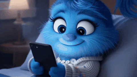 A blue furry cartoon character lies in bed smiling while looking at a phone, then closes its eyes.