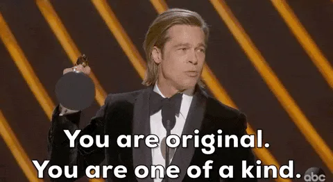 A man in a tuxedo holds an award and says 'You are original, you are one of a kind.'