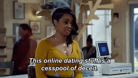 A woman in a yellow top at a counter says 'This online dating stuff is a cesspool of deceit.'