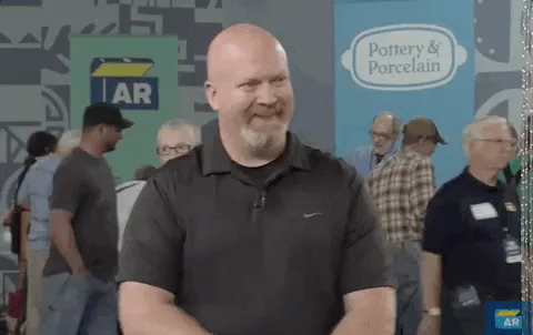 A bald man in a gray shirt smiles at a crowded event, captioned 'Great investment.'