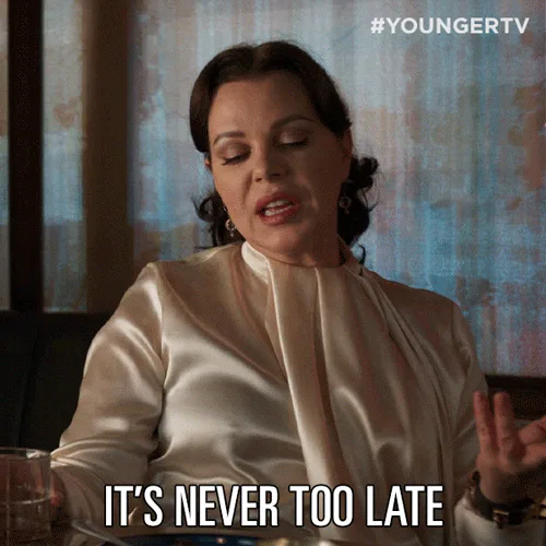 A woman in a satin blouse speaks and says 'It's never too late.'