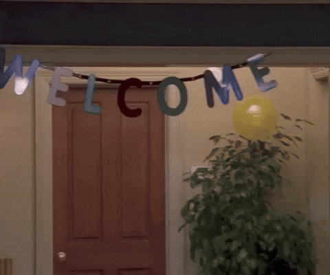 A person walks beneath a doorway banner that reads 'Welcome.'
