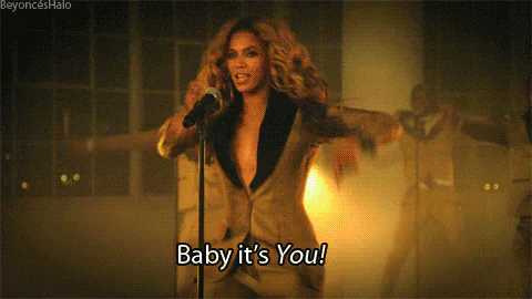 A woman in a gold-lapel suit sings into a microphone as on-screen text reads 'Baby it's You!'