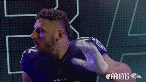 15982cd9-2892-f1b7-43d5-bcee021b0273.gif A football player in a Ravens jersey cups a white-gloved hand near his ear.