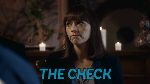 A woman at a candlelit table speaks as on-screen text reads 'The check.'