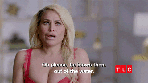 A blonde woman smiles and says, "Oh please, he blows them out of the water."