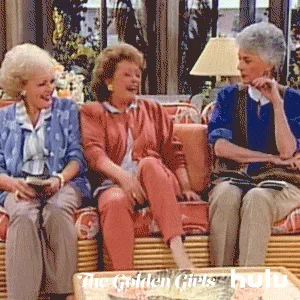 Three older women sit together on a couch laughing, from a classic sitcom.