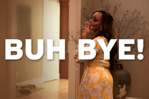 A woman in a floral dress waves goodbye in a hallway as on-screen text reads 'Buh bye!'