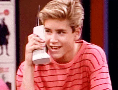 Saved+By+The+Bell+80S+GIF.gif A young man on a retro brick-sized phone smiles and laughs while chatting.