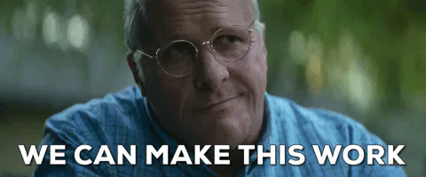 A bald man in glasses and a blue shirt outdoors says 'We can make this work.'