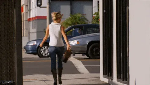 Walk+Away+Heidi+Montag+GIF+by+The+Hills.gif A woman in a white top and jeans walks away from the camera past a parked car on a sunny street.