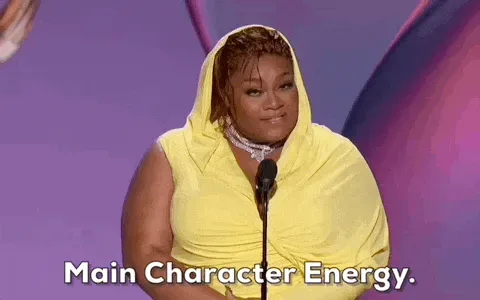 Primetime+Emmys+Energy+GIF+by+Emmys.gif A woman in a yellow draped gown speaks at a microphone as text reads 'Main Character Energy.'