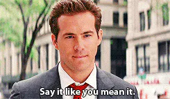 A man in a suit and red tie says, 'Say it like you mean it.'
