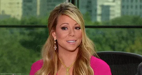 Confused+Mariah+Carey+GIF.gif A woman with wavy blond hair sits in an office chair, smiling as she talks with a city skyline behind her.