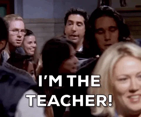 A man in a crowd of people shouts 'I'm the teacher!' in a scene from Friends.