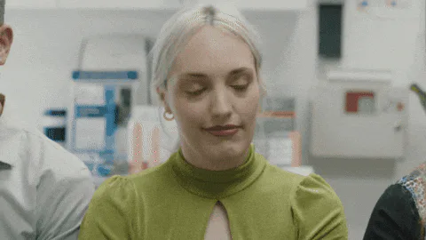 A blond woman blinks and speaks in a lab setting, with the word 'Location' appearing stacked across the screen.