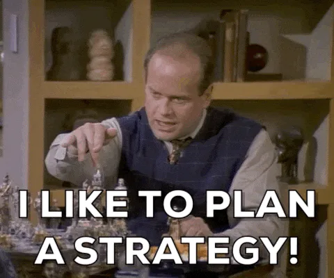 A balding man in a cardigan moves a chess piece and says 'I like to plan a strategy!'