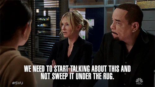 A woman and a man in an office say 'We need to start talking about this and not sweep it under the rug.'