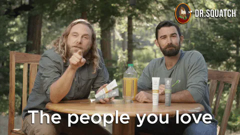 Two bearded men sit at an outdoor table with grooming products and one says 'The people you love.'