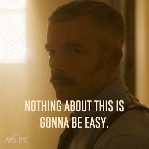 A man in a military style coat with a mustache says 'Nothing about this is gonna be easy.'