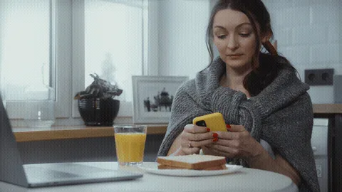 cand-6337132 (Pexels, Tima Miroshnichenko) - livestream GIF replacement Woman checking her phone at the kitchen table with a glass of juice
