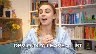 A woman with braided hair gestures in front of a bookshelf and says 'Obviously, I have a list.'