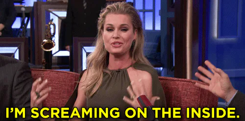 A blonde woman in an olive dress gestures with both hands on a talk show set and says 'I'm screaming on the inside.'