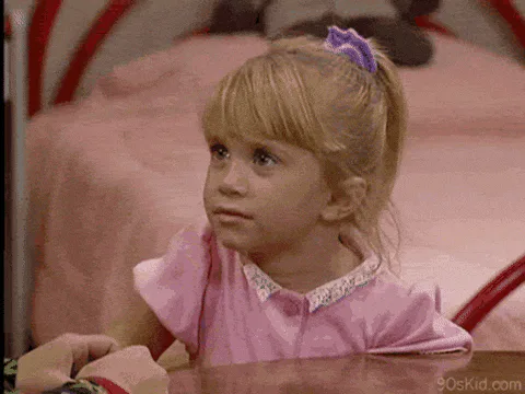 A little girl with blond pigtails in a pink dress rolls her eyes and says 'Duh!'