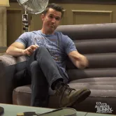 Season+16+Fx+GIF+by+It's+Always+Sunny+in+Philadelphia.gif A man in a t-shirt sits on a couch with his fingers laced together, captioned 'Have a seat.'