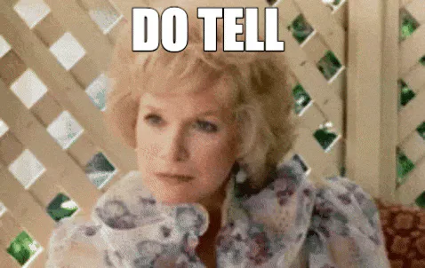 An older blonde woman raises her eyebrows and says 'Do tell.'