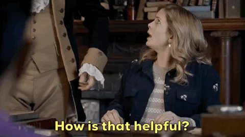 A woman in a denim jacket in a library looks up and asks, 'How is that helpful?'