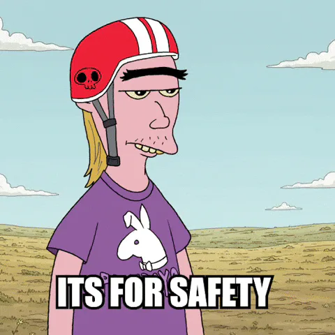 A cartoon man in a red helmet points at his temple and says 'It's for safety.'