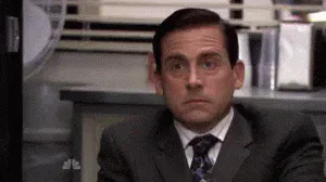 Interested+Ooo+GIF+by+reactionseditor.gif A man in a suit rests his chin on his clasped hands, raising his eyebrows playfully.