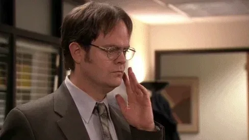 5wWf7GR2nhgamhRnEuA.webp A bespectacled man in a grey suit rests his fingers on his cheek with a puzzled look in an office.