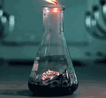 chemistry+GIF.gif A glass flask on a lab bench produces a bright green flame that grows and flickers upward.