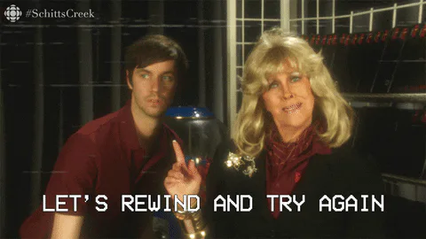 A man and woman with big blonde hair sit together as she says 'Let's rewind and try again.'