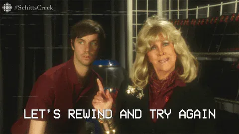 e06fcf52-cf7a-5cbc-9c76-240589ec1f0f.gif A man and woman with big blonde hair sit together as she says 'Let's rewind and try again.'