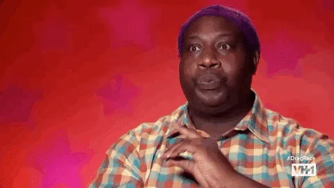 A man in a plaid shirt and purple beanie gestures and shouts 'Eat it!'