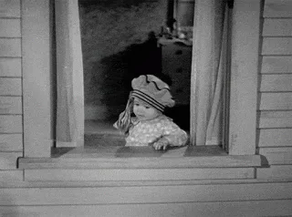 A black-and-white film shows a toddler at a window as paper money flutters past.