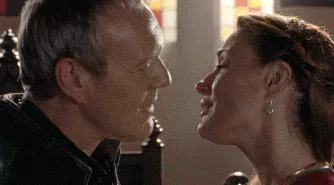 Uther+Pendragon+Bad+Breath+GIF.gif A man exhales glowing green breath toward a woman's face in a candlelit medieval hall.