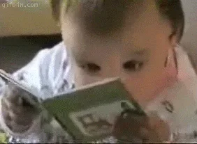 Read+Book+Club+GIF.gif A baby holds a picture book close to its face, appearing to read intently.