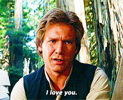 A man in a vest looks intently at the camera in a forest, captioned 'I love you.'