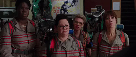 The Ghostbusters cast looks alarmed together in their firehouse headquarters.