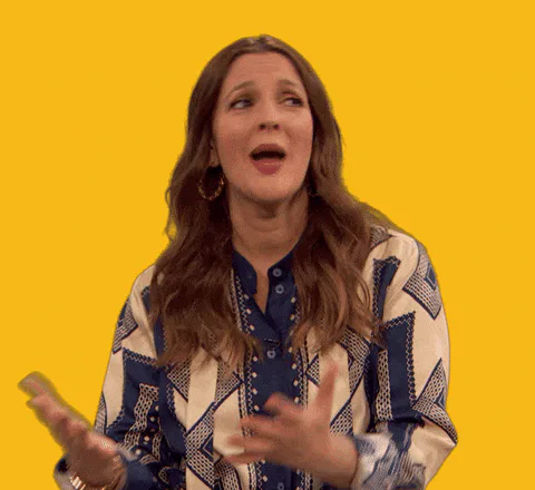 A woman with long brown hair claps and presses her hands together in a thank-you gesture against a yellow background.