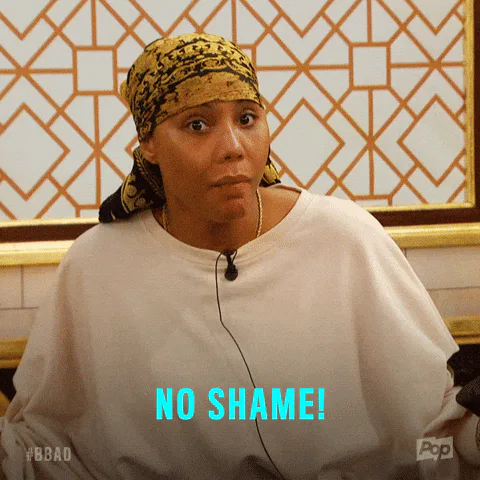 A woman in a gold headscarf speaks emphatically in a spa robe, captioned 'No shame!'
