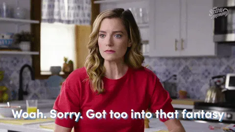 Sorry+Fantasy+GIF+by+Scary+Mommy.gif A woman in a red shirt in a kitchen raises her hand and says 'Woah, sorry, got too into that fantasy.'