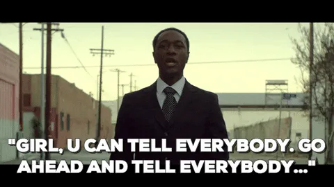A man in a suit walks down an alley and says 'Girl, u can tell everybody. Go ahead and tell everybody...'